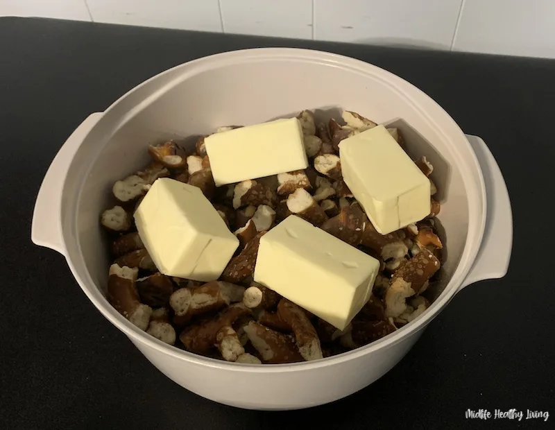 bowl with smashed pretzels and butter on top ready for the microwave