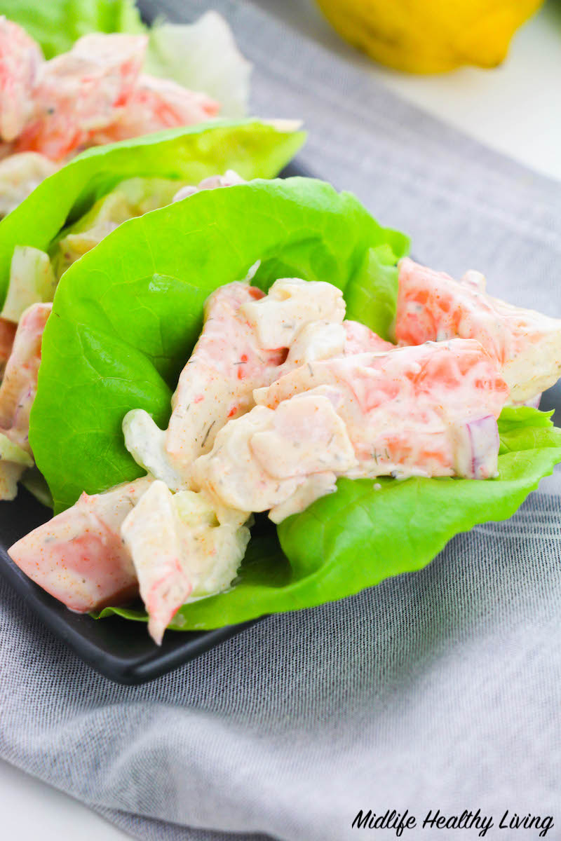 A finished lettuce wrap filled with seafood salad
