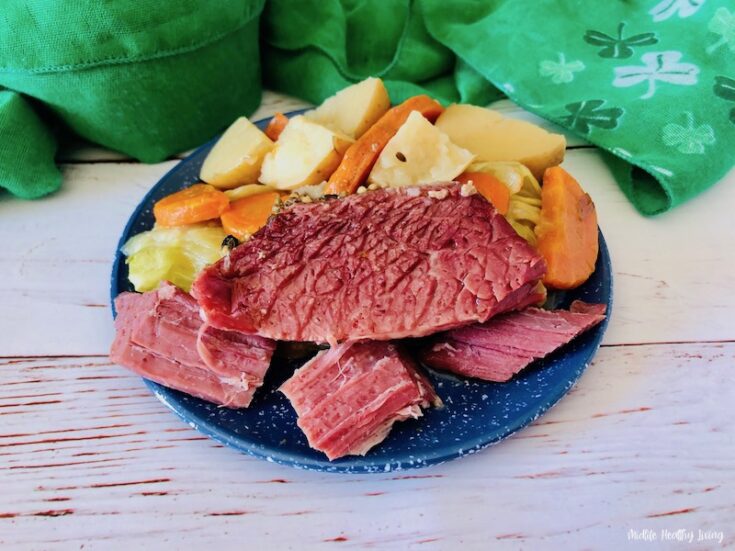 Featured image showing a plate full of veggies and the Crock pot corned beef and cabbage ready to eat.