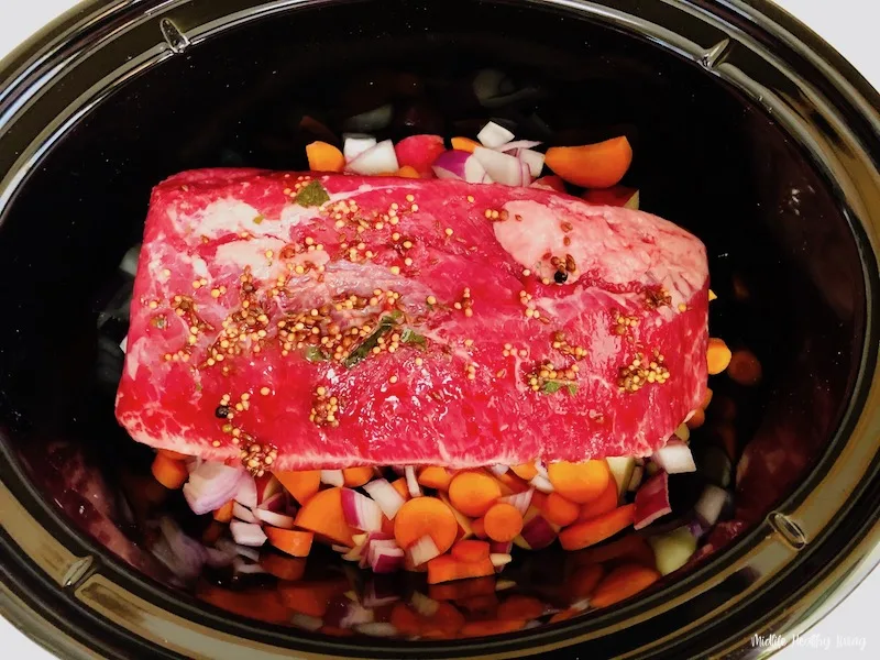Corned beef added to the crockpot. 