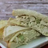 Sliced dilled chicken salad, one on top of the other served on a white plate.