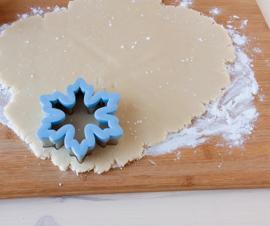 cookies being cut with cookie cutters. 