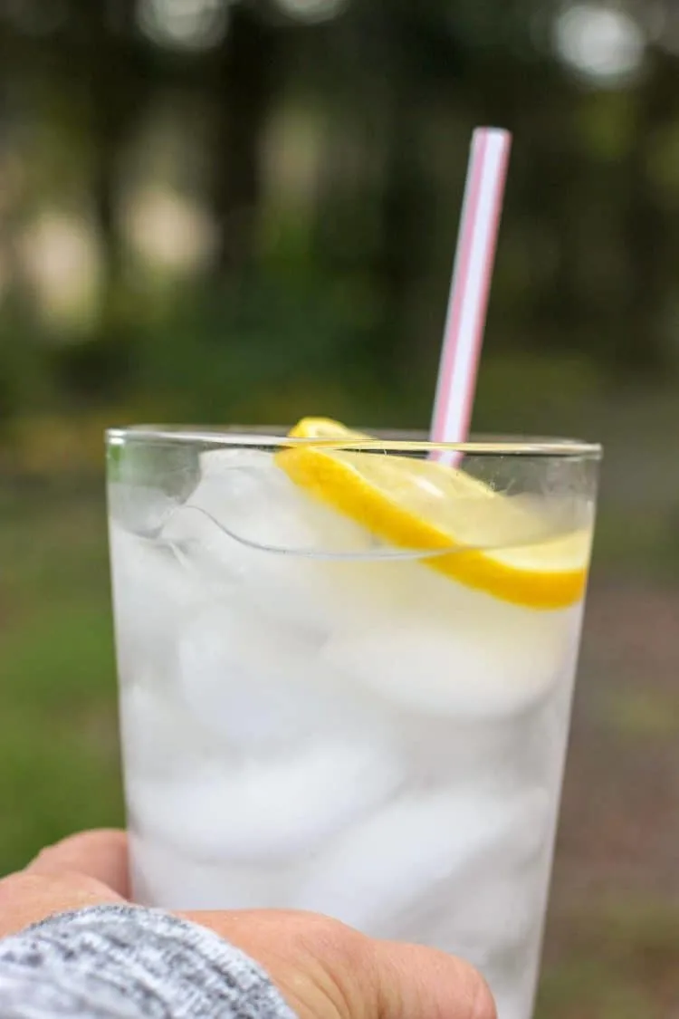 glass with ice, lemon slice and straw. 