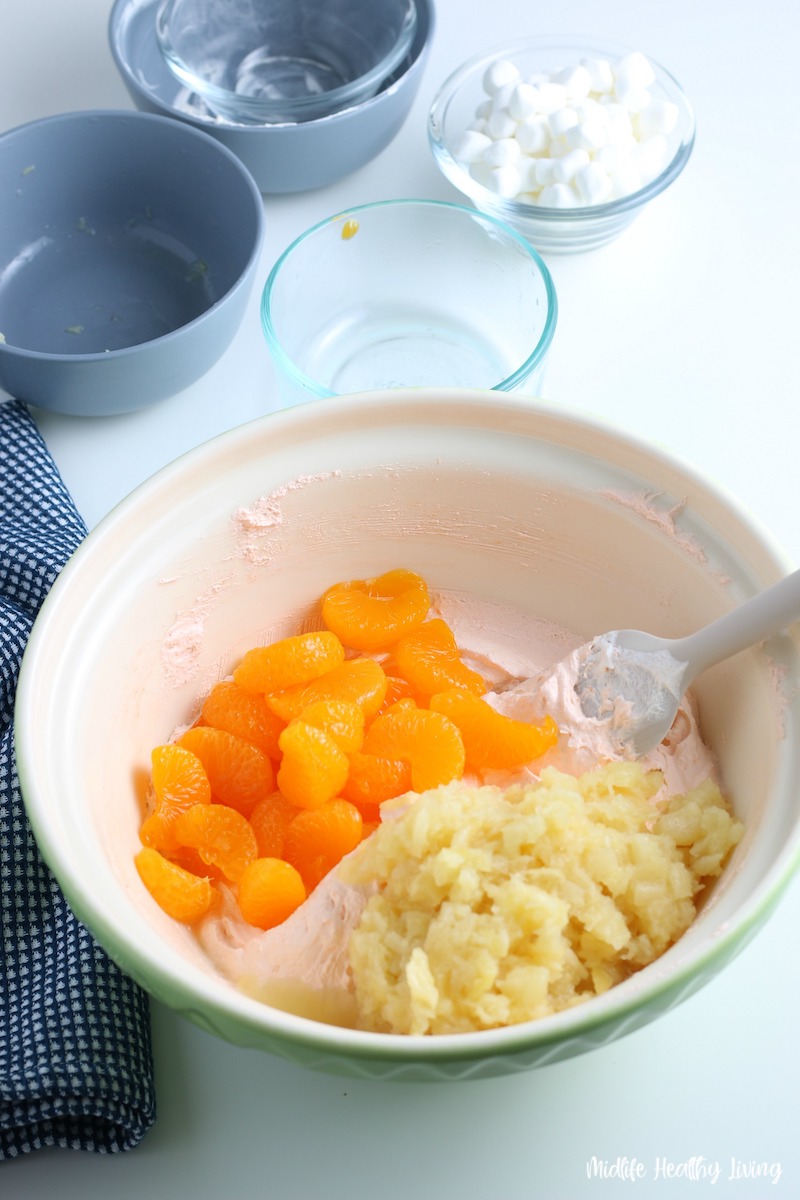 More ingredients going in to make orange fluff jello salad. 