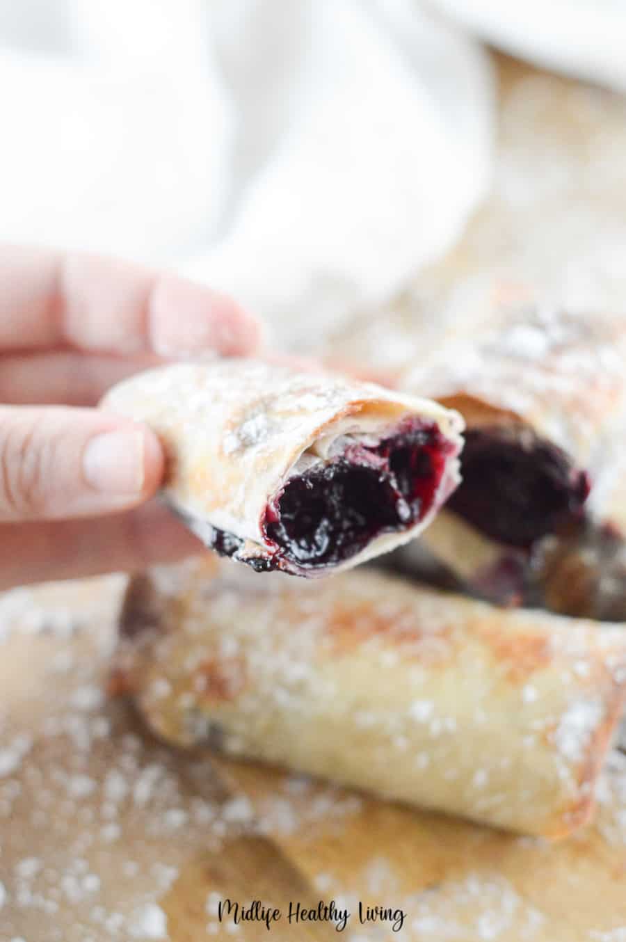 A close up view of a finished cherry pie recipe cut in half to show the indulgent middle. 