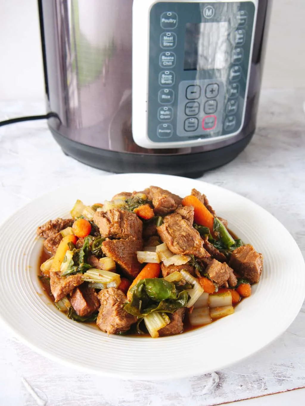 Finished beef stew recipe with the Instant Pot in the background. 
