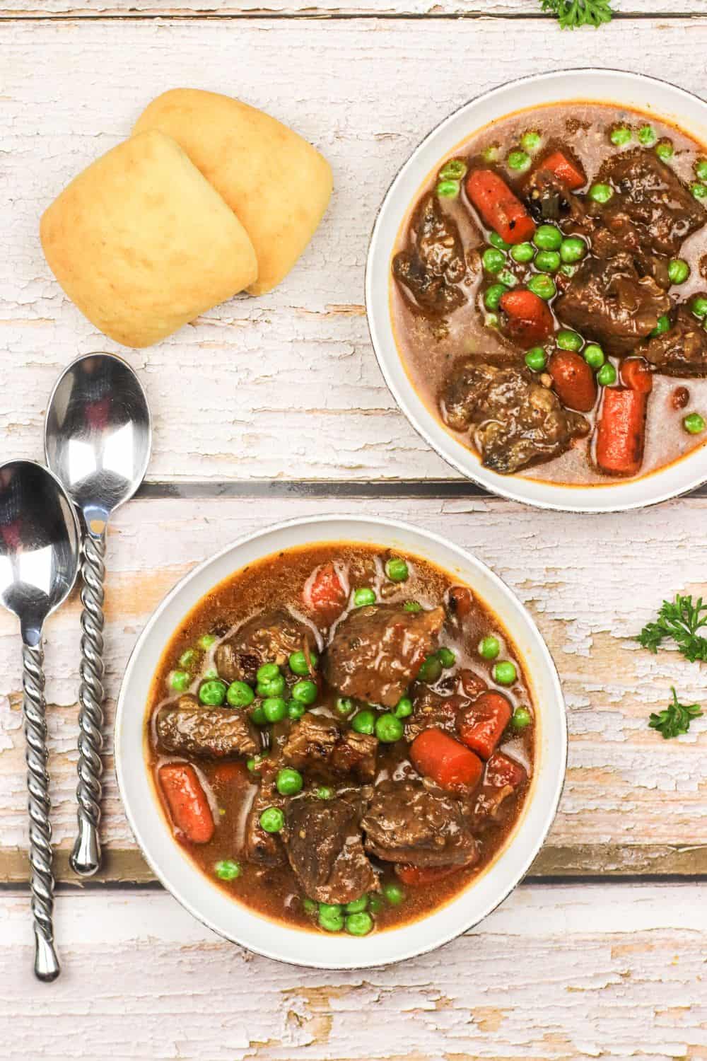 serving beef stew in two white bowls photographed from above