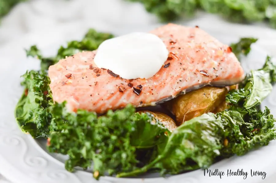 A close up shot showing the deliciousness of the salmon with the creamy yogurt sauce on top. 