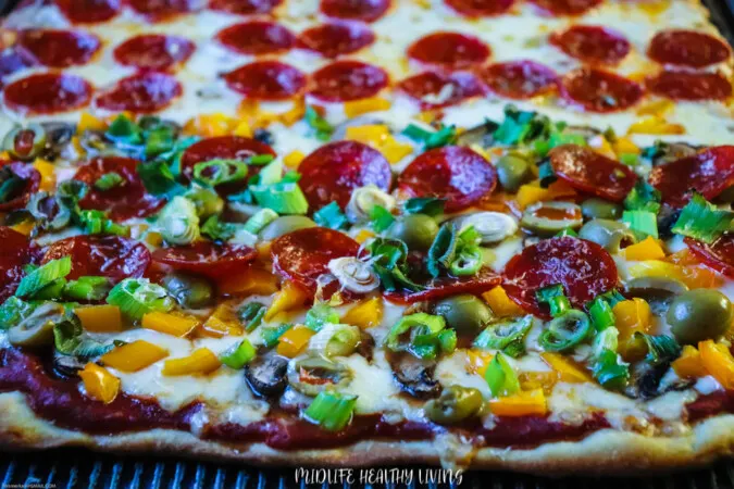 A look at a full pizza with toppings split in half so the whole family can have what they love. 