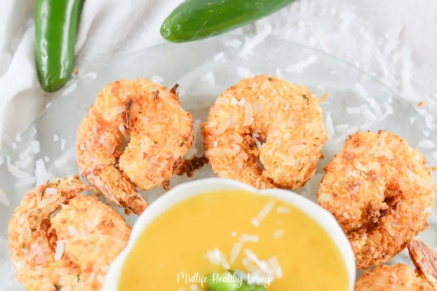The coconut shrimp are arranged around the bowl of mango sauce, ready to be dipped and eaten. 
