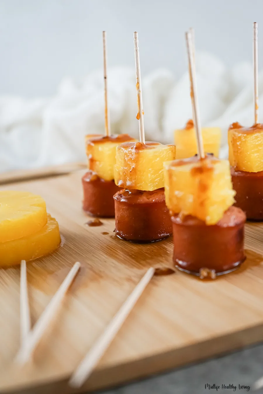 Sausage pineapple bites ready to eat on a cutting board. 
