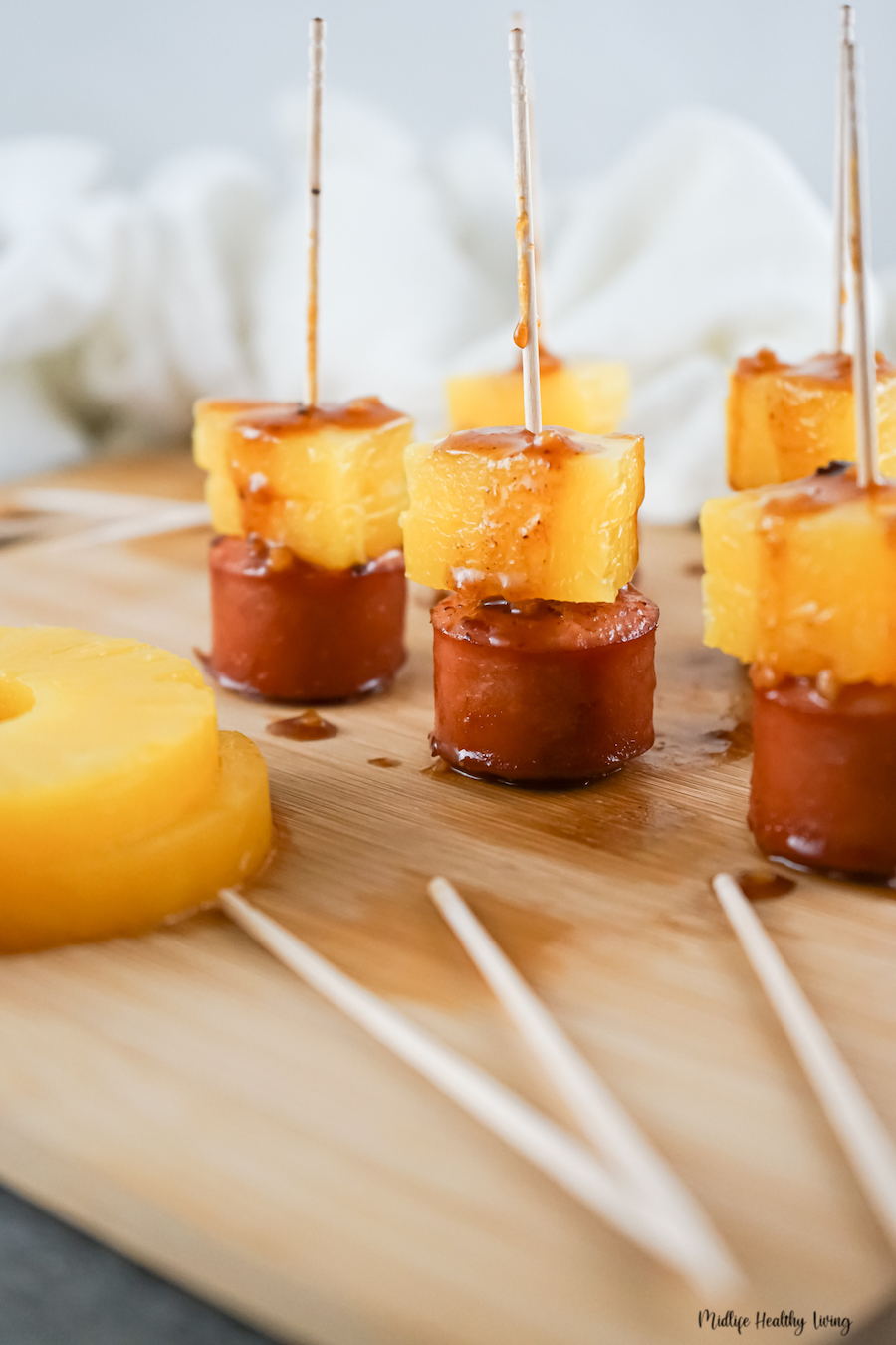 A close up view of the finished pineapple sausage bites ready to serve with skewers.
