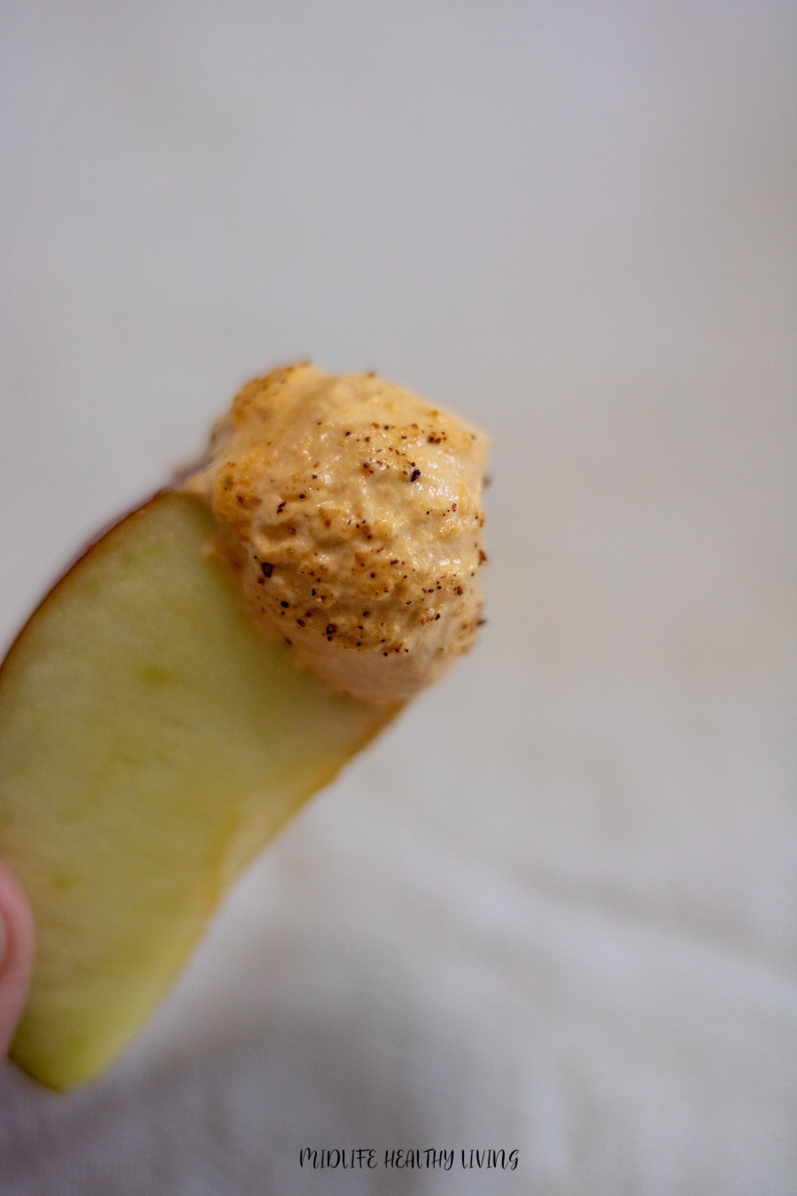 A scoop of the pumpkin fluff for weight watchers on an apple slice ready to eat. 