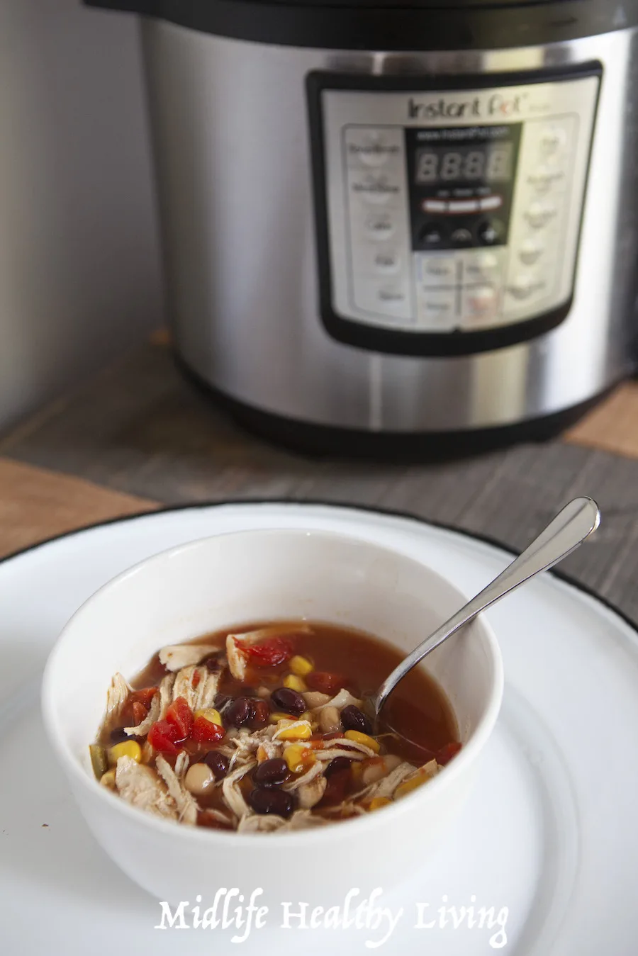 A finished bowl of the weight watchers taco soup ready to eat in front of the pressure cooker. 