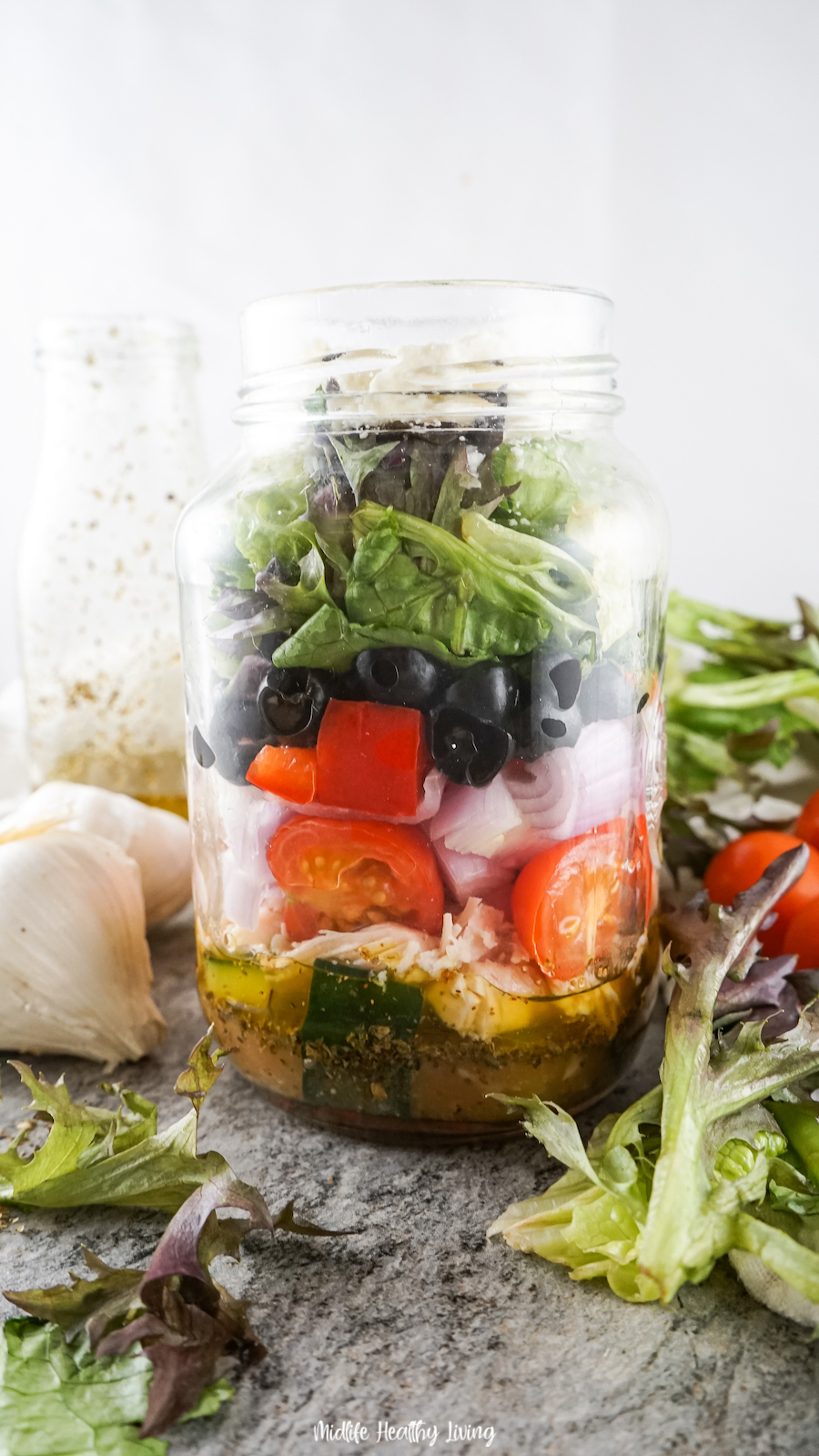 This image shows the finished greek salad in a jar ready to serve. 
