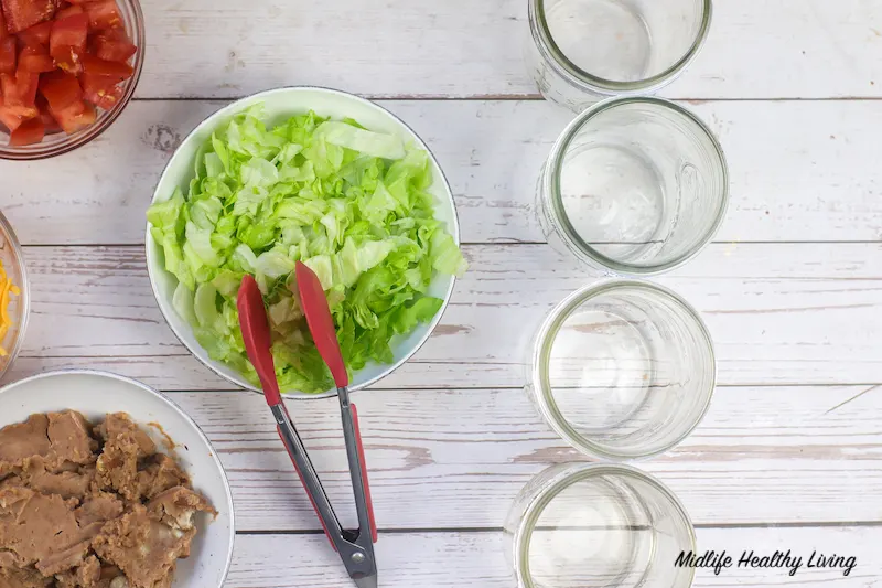 Adding lettuce to the empty jars