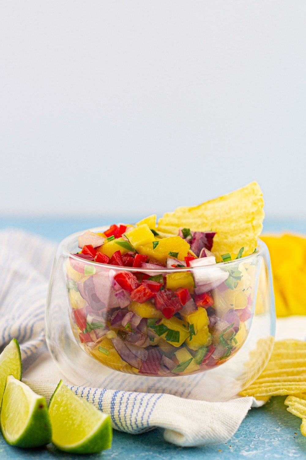 Mango Habanero Salsa in a glass bowl with a chip