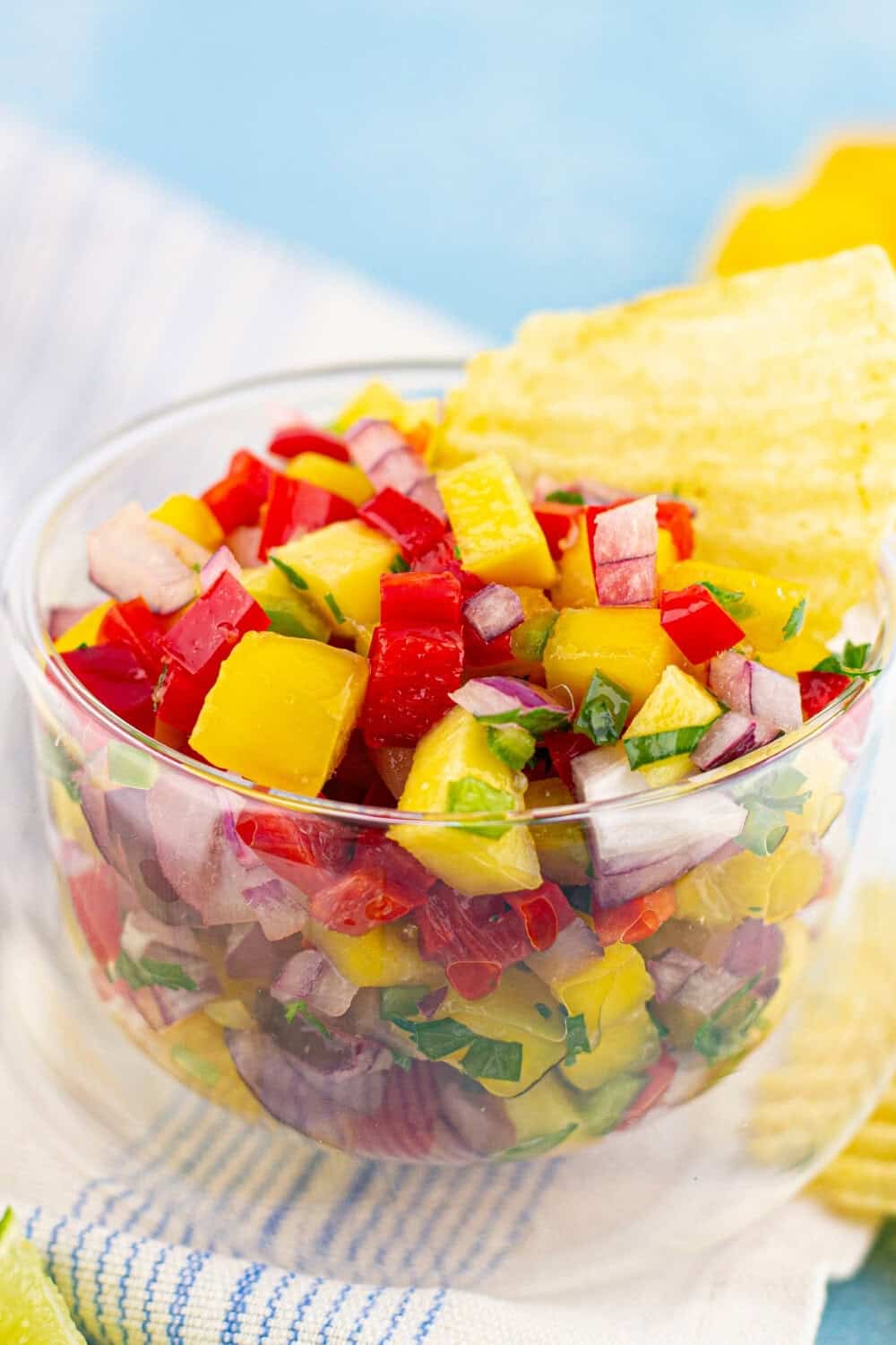 Mango Habanero Salsa in a glass bowl with a chip