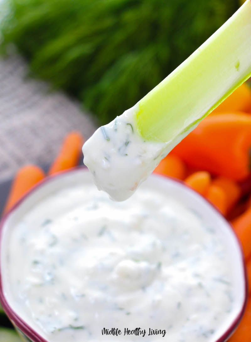 A close up of the finished dip on a piece of celery ready to eat. 