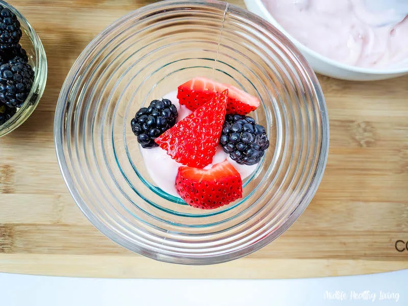 fruit being added in layers to the trifle bowl.
