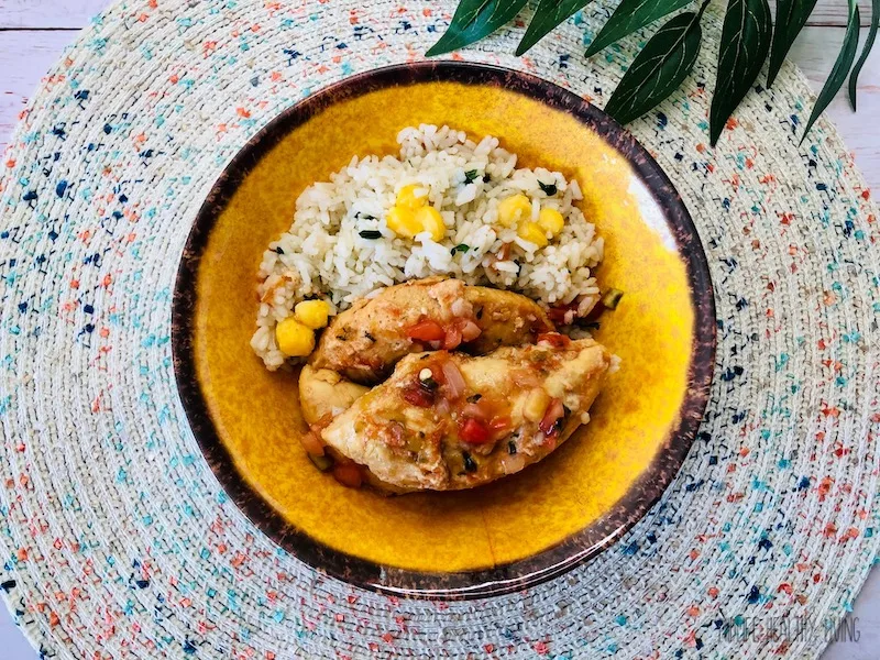 A top down look at a plate with salsa chicken and rice. 