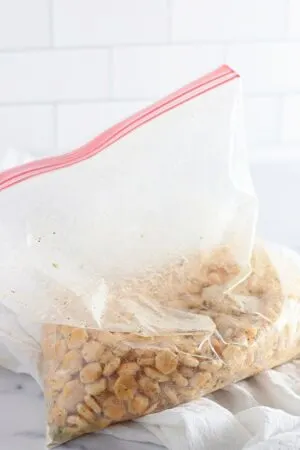 oyster crackers being mixed in a bag with seasoning