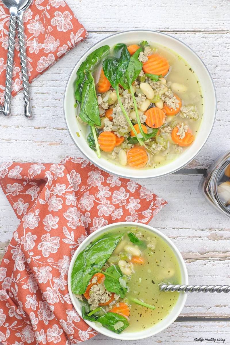 Top down view of two bowls of the finished ground turkey soup with beans.