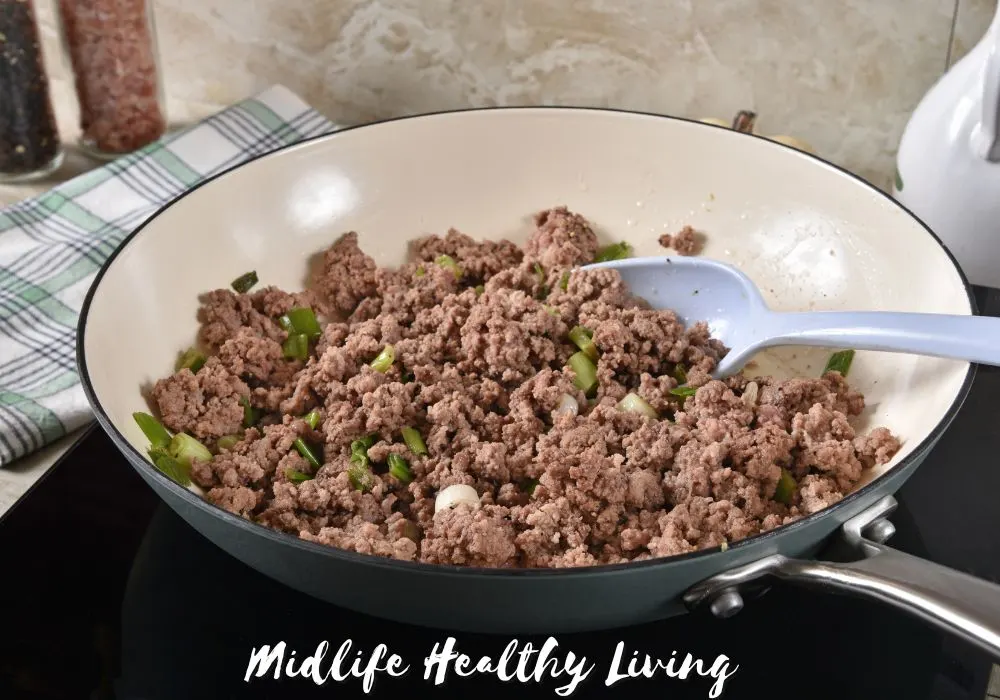 Ground turkey being browned in a skillet with onions.