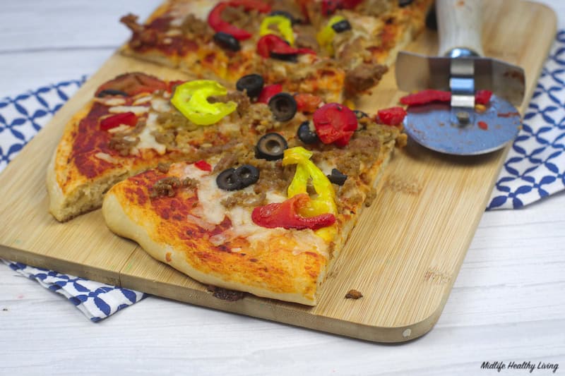 Finished pizza on a cutting board ready to serve. 