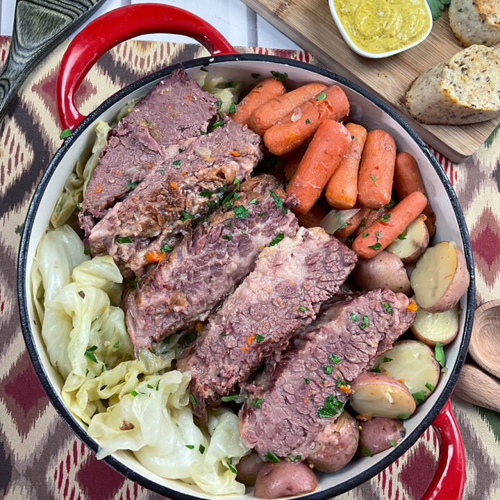 Completed corned beef surrounded by carrots, onions, potatoes and cabbage