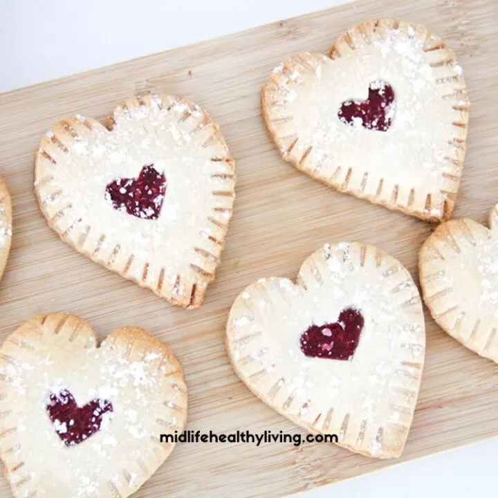 a close up of raspberry hand pies on a cutting board