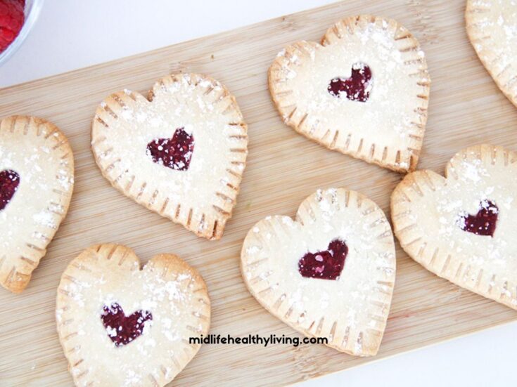 a close up of raspberry hand pies on a cutting board