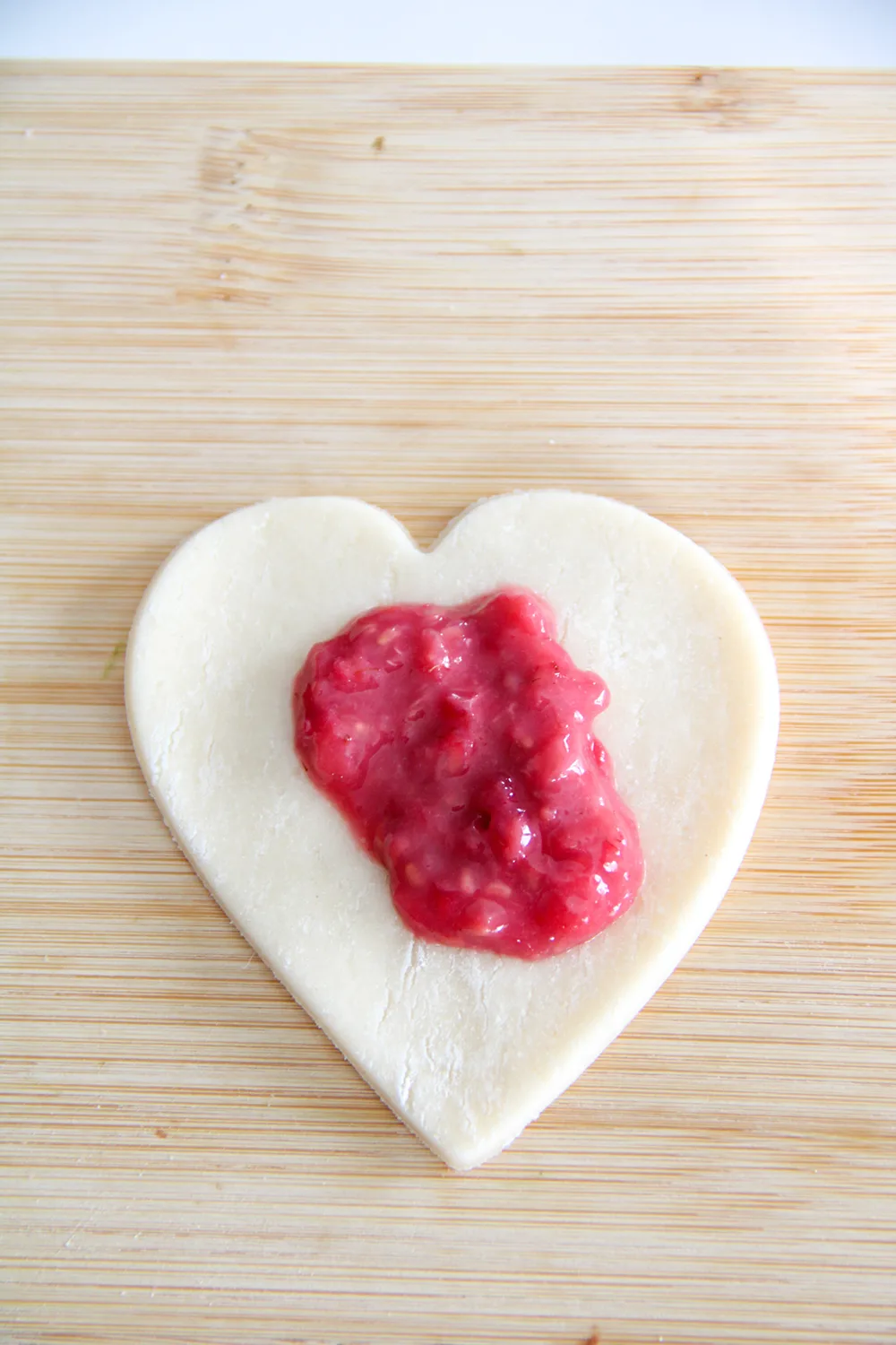 heart shaped dough with raspberry filling on top