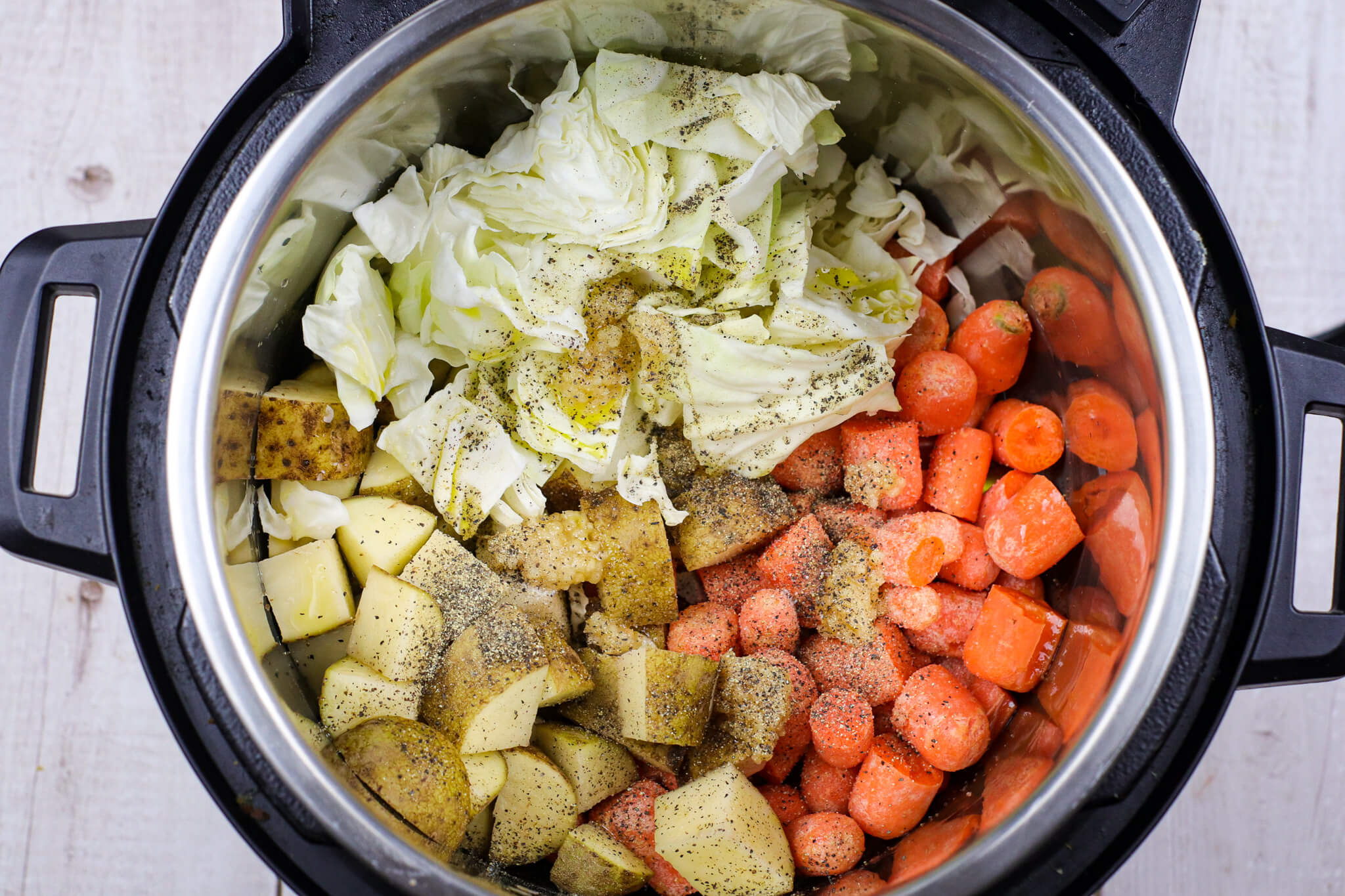 cabbage potatoes and carrots seasoned in a slow cooker
