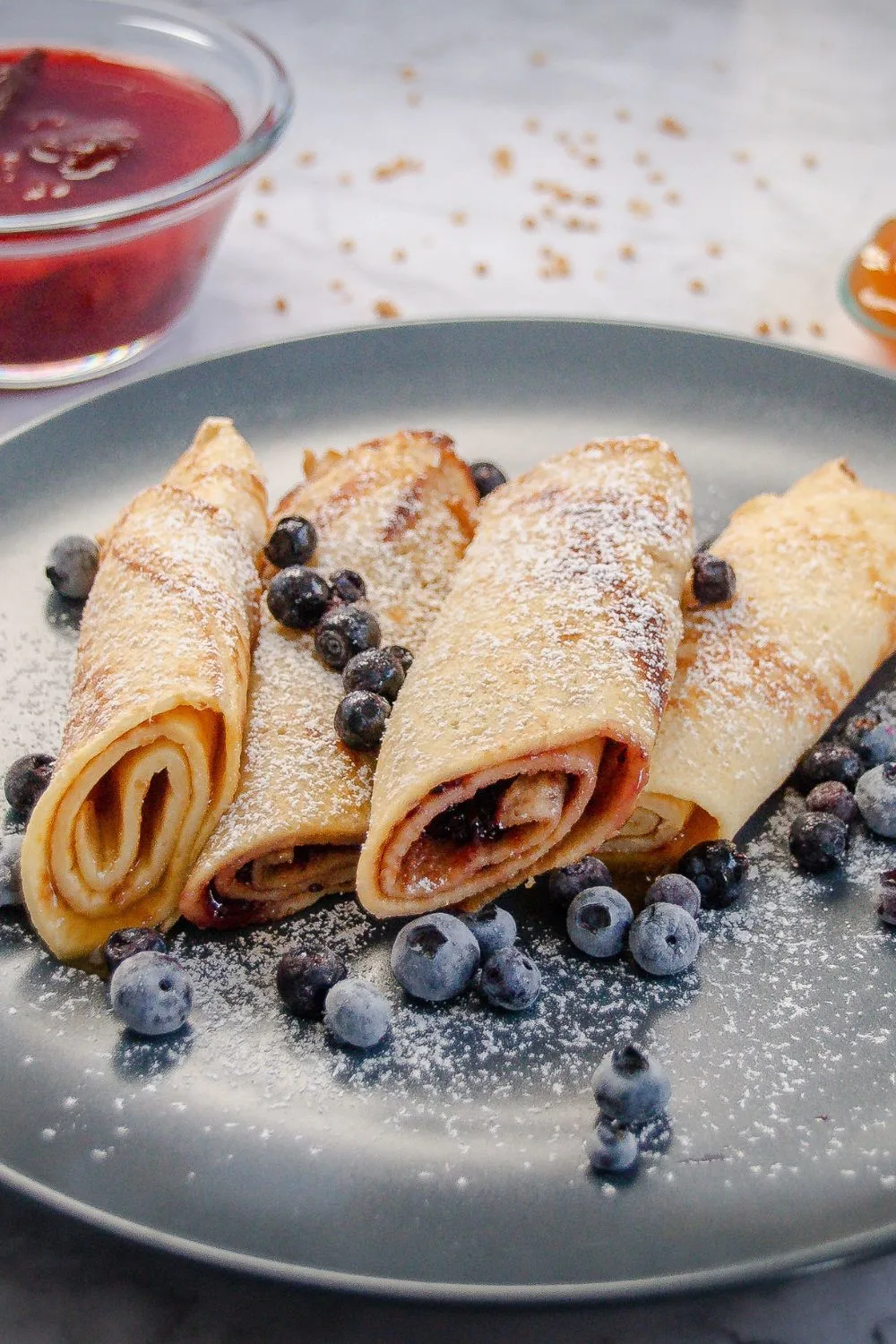 rolled up crepes with blueberries on a plate