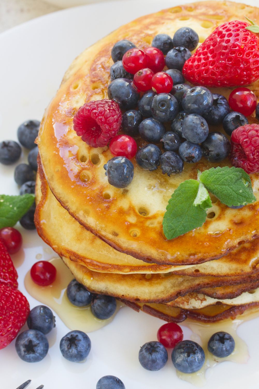 pancakes stacked on a plate topped with berries