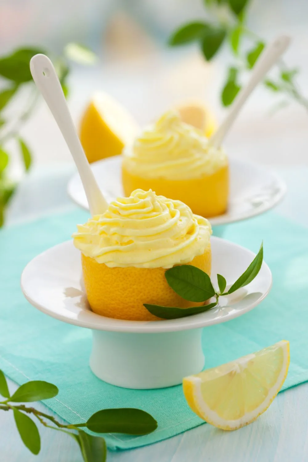 lemons on dessert plates on a teal background