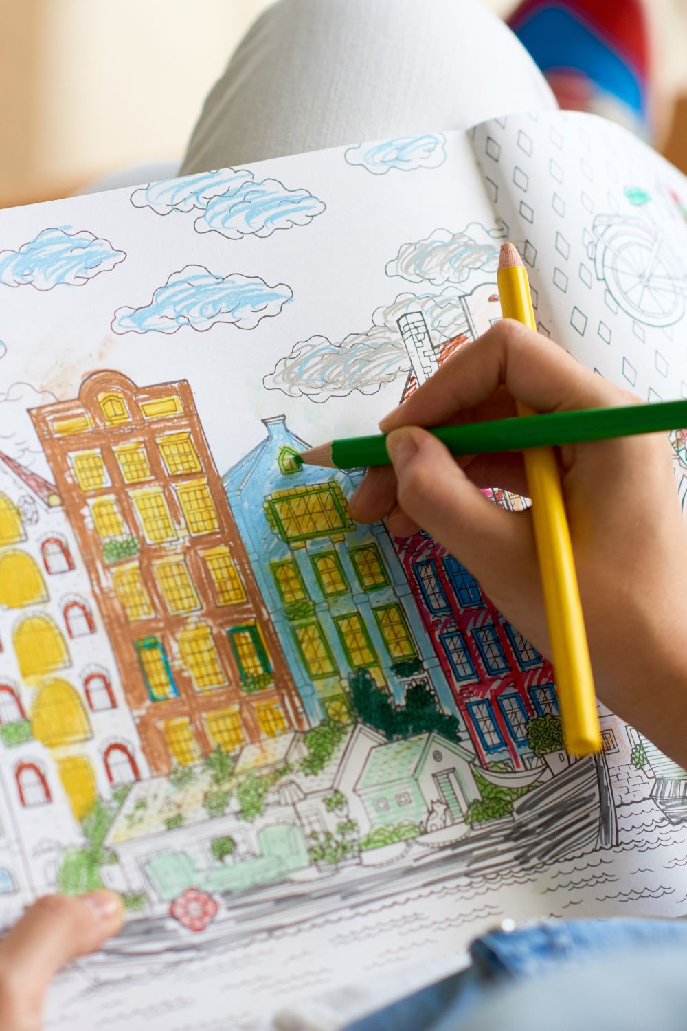 person coloring in a picture of buildings