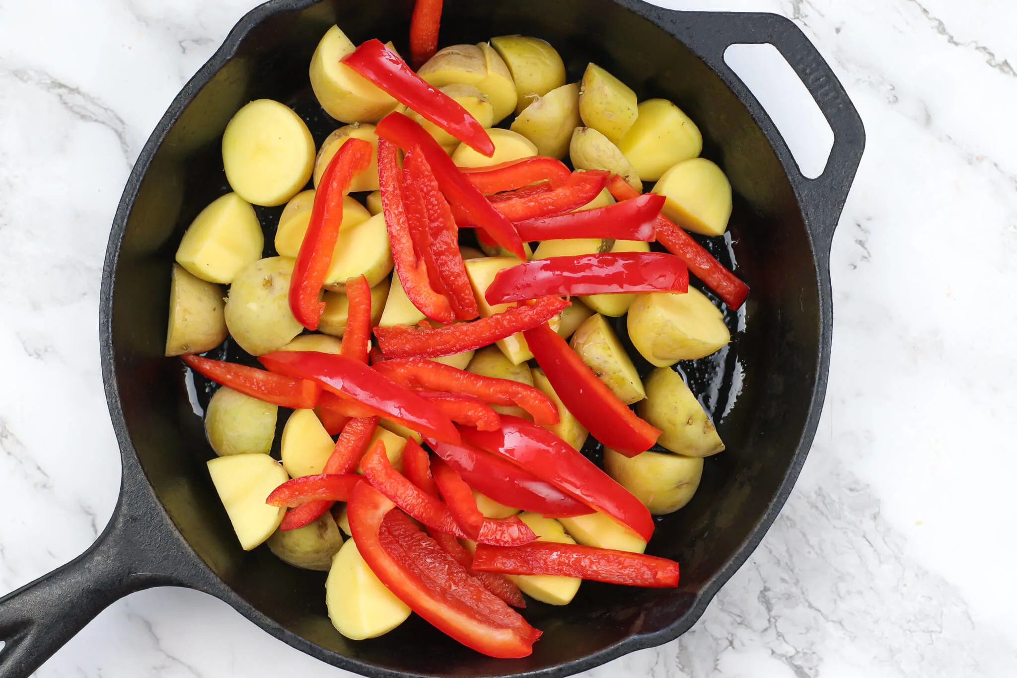 diced potatoes and sliced peppers in a skillet for chicken skillet