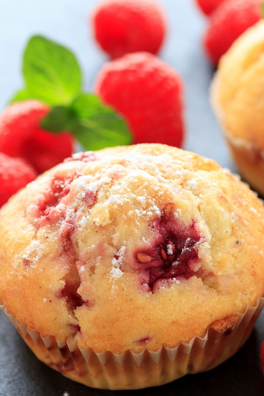 raspberry muffin with raspberries in the background