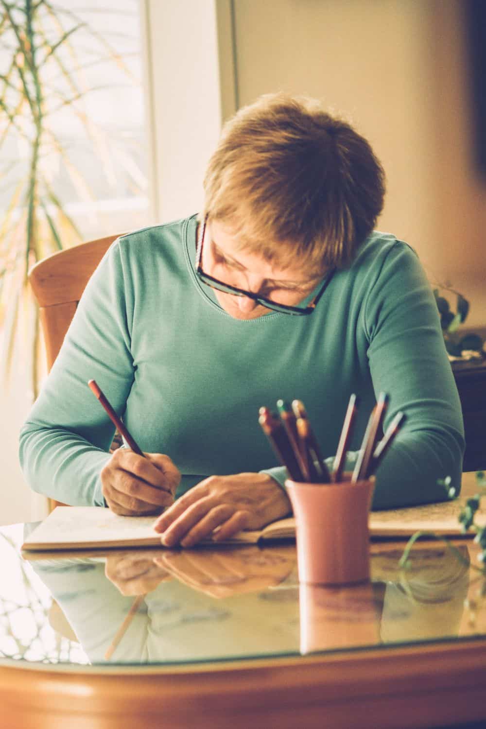 a woman sitting at a table coloring