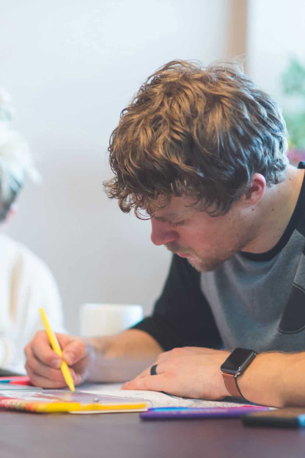 a man and woman sitting together and coloring