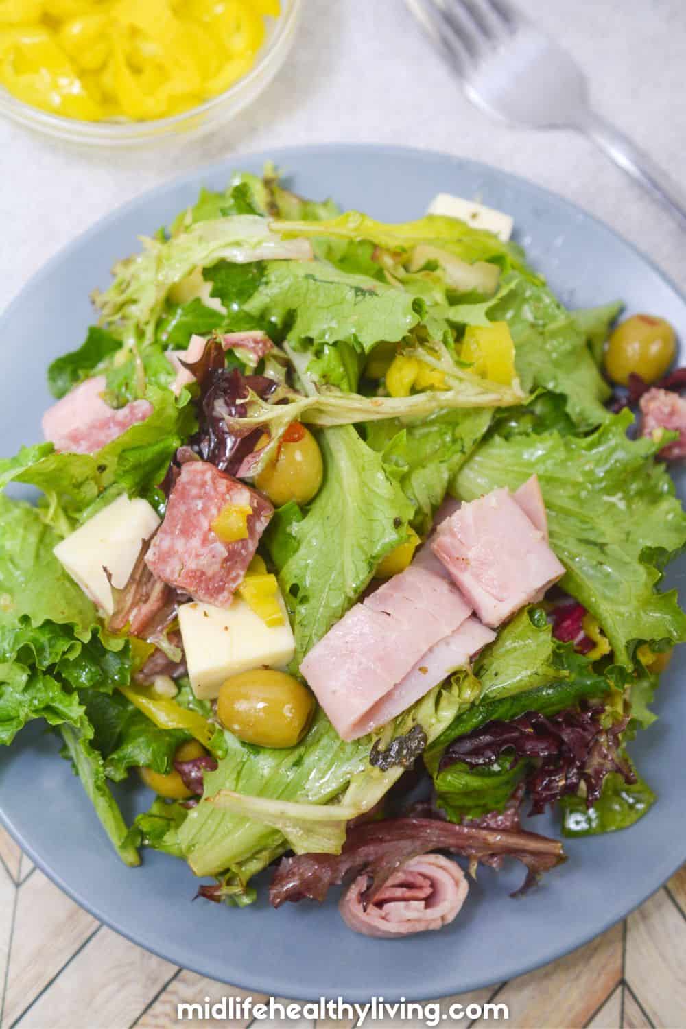 Keto friendly antipasto salad on a blue plate from above