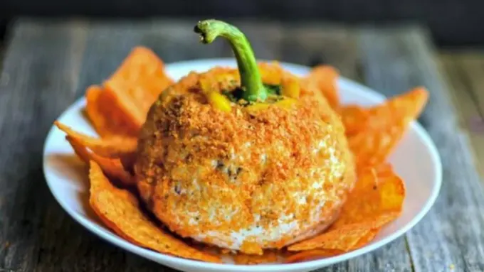 A cheese ball shaped like a cheesy pumpkin.