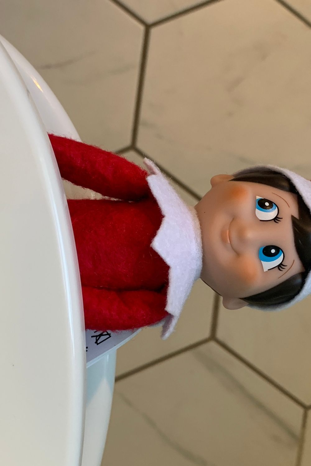 Elf on the Shelf hiding on the toilet
