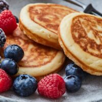 pancakes on a plate surrounded by berries