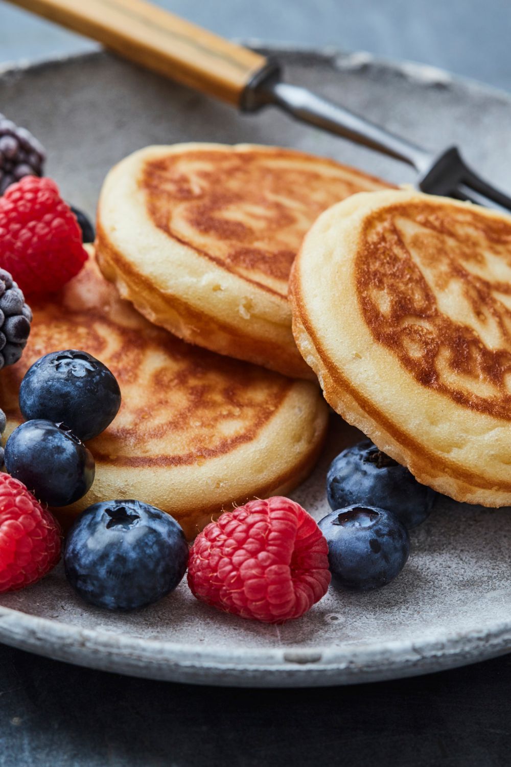 pancakes on a plate surrounded by berries