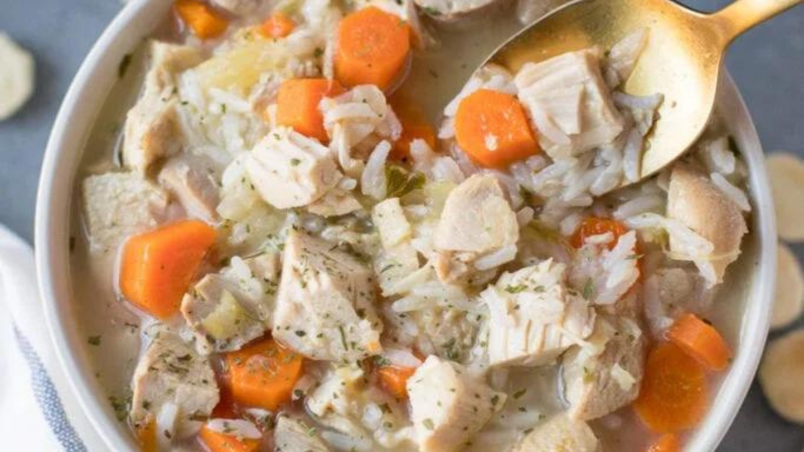 A bowl of turkey, carrot and rice soup.