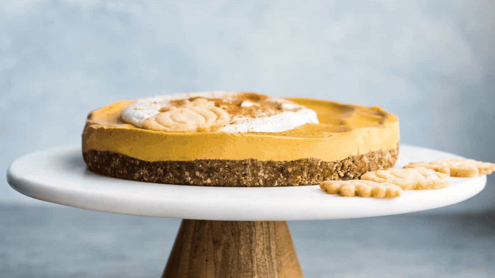 A thin vegan pumpkin pie on a pedestal. 