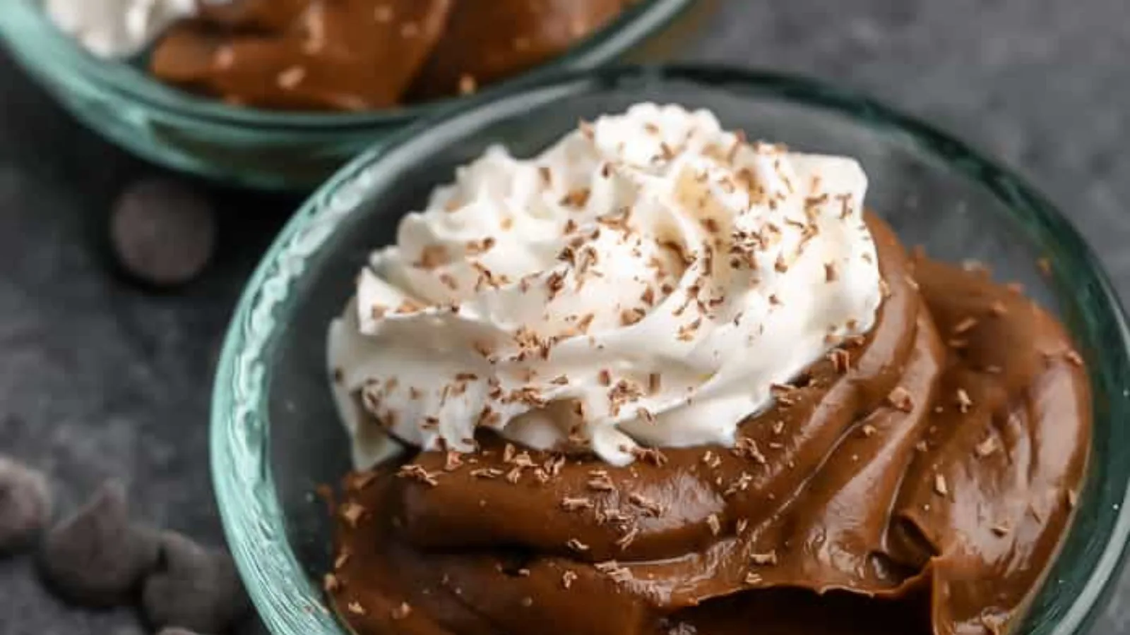 Bowls of chocolate pudding made with avocado and topped with whipped cream.